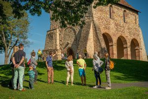 Eine Gruppe steht während einer Führung am Kirchenrest